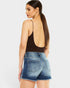 Woman wearing a brown open-back top and denim shorts on a white background