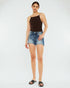 Woman wearing a black tank top and denim shorts on a white background