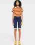Person wearing a striped shirt and denim shorts on a plain background