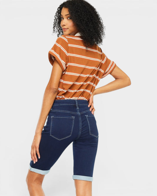 Woman wearing a striped shirt and blue shorts on a white background