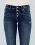 Blue jeans with button details on a light gray background