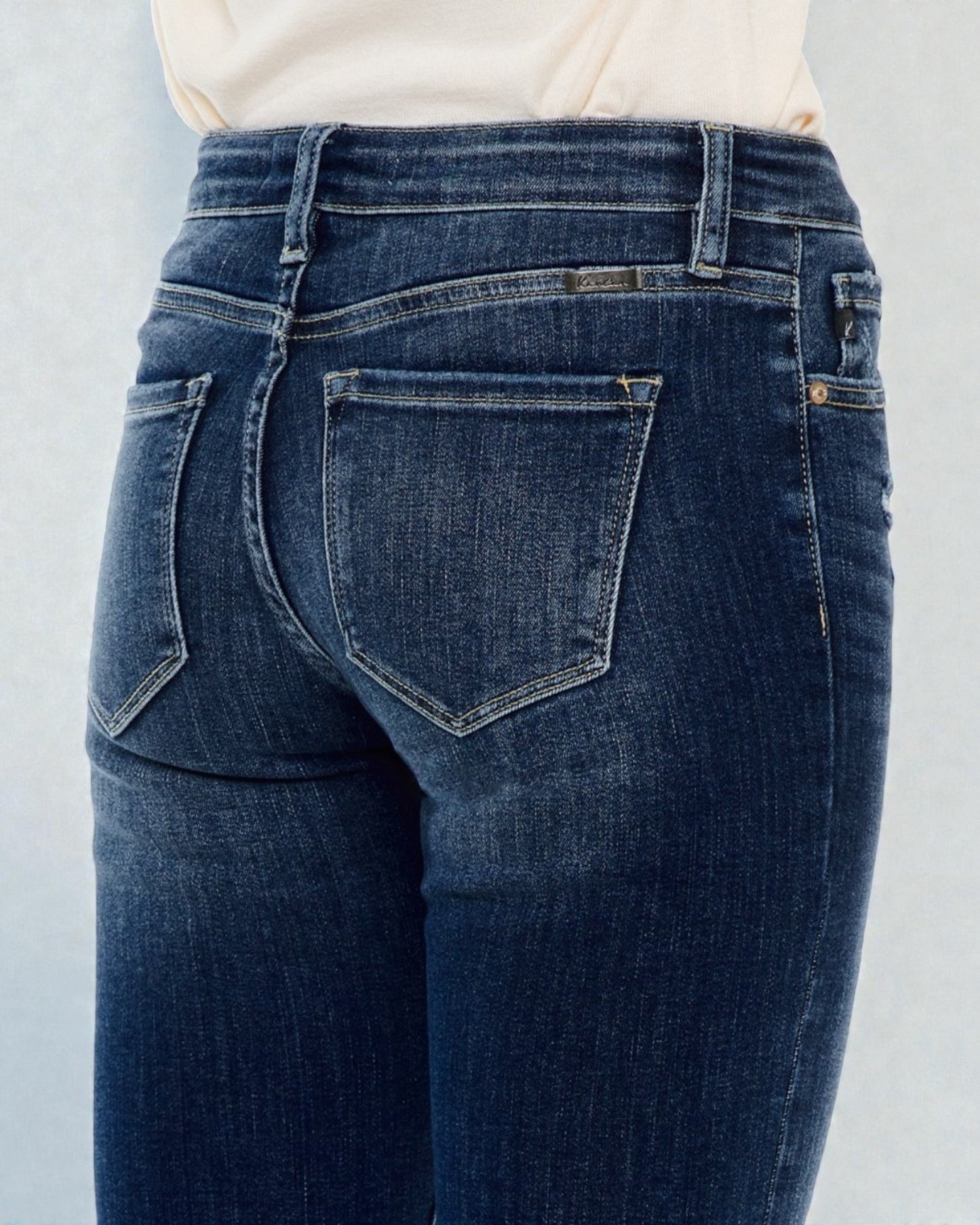 Blue jeans worn by a person on a light gray background