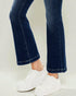 Dark blue jeans with white sneakers on a light gray background