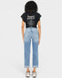 Person wearing a black t-shirt with text and light blue jeans on a white background