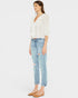 Woman wearing a white blouse and light blue jeans on a white background
