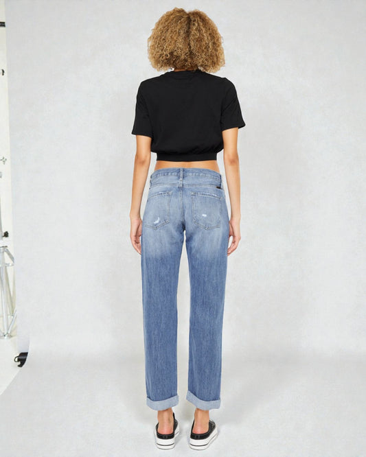 Person wearing a black t-shirt and blue jeans against a white background