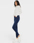 Woman wearing a white patterned sweater and blue jeans on a white background
