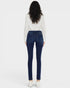 Woman wearing blue jeans and a white blouse with black patterns on a white background