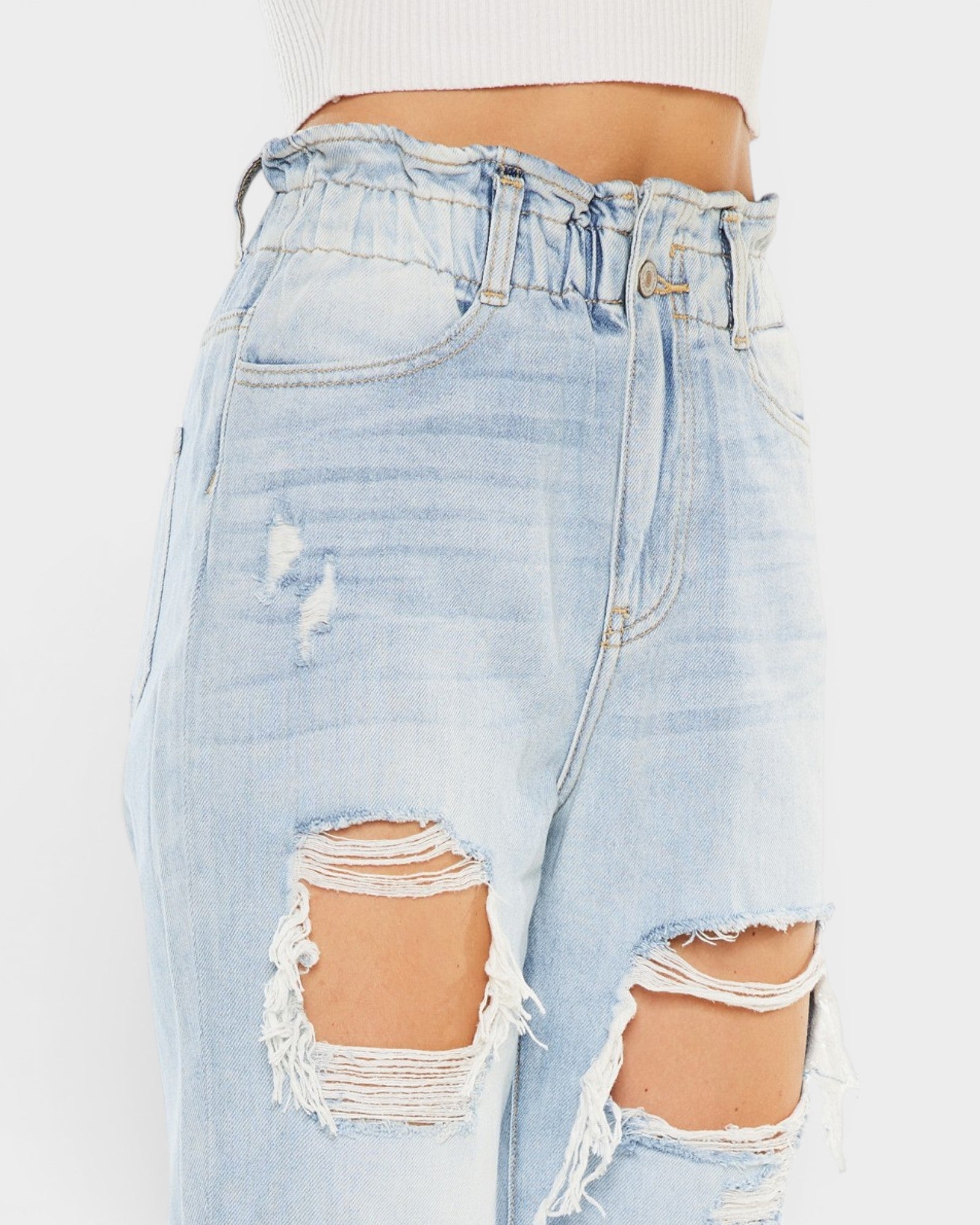 Light blue distressed denim shorts on a white background