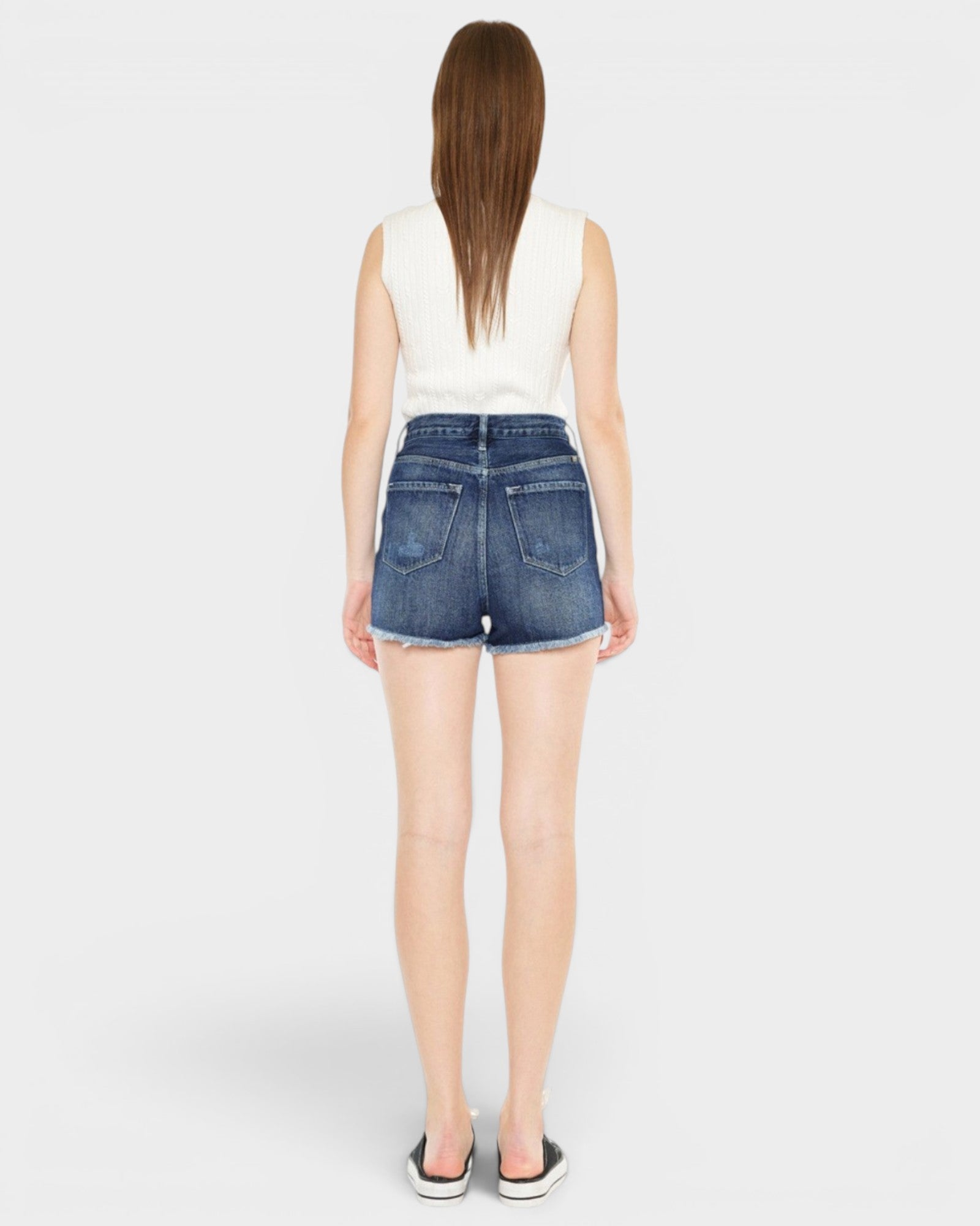 Person wearing blue denim shorts on a white background
