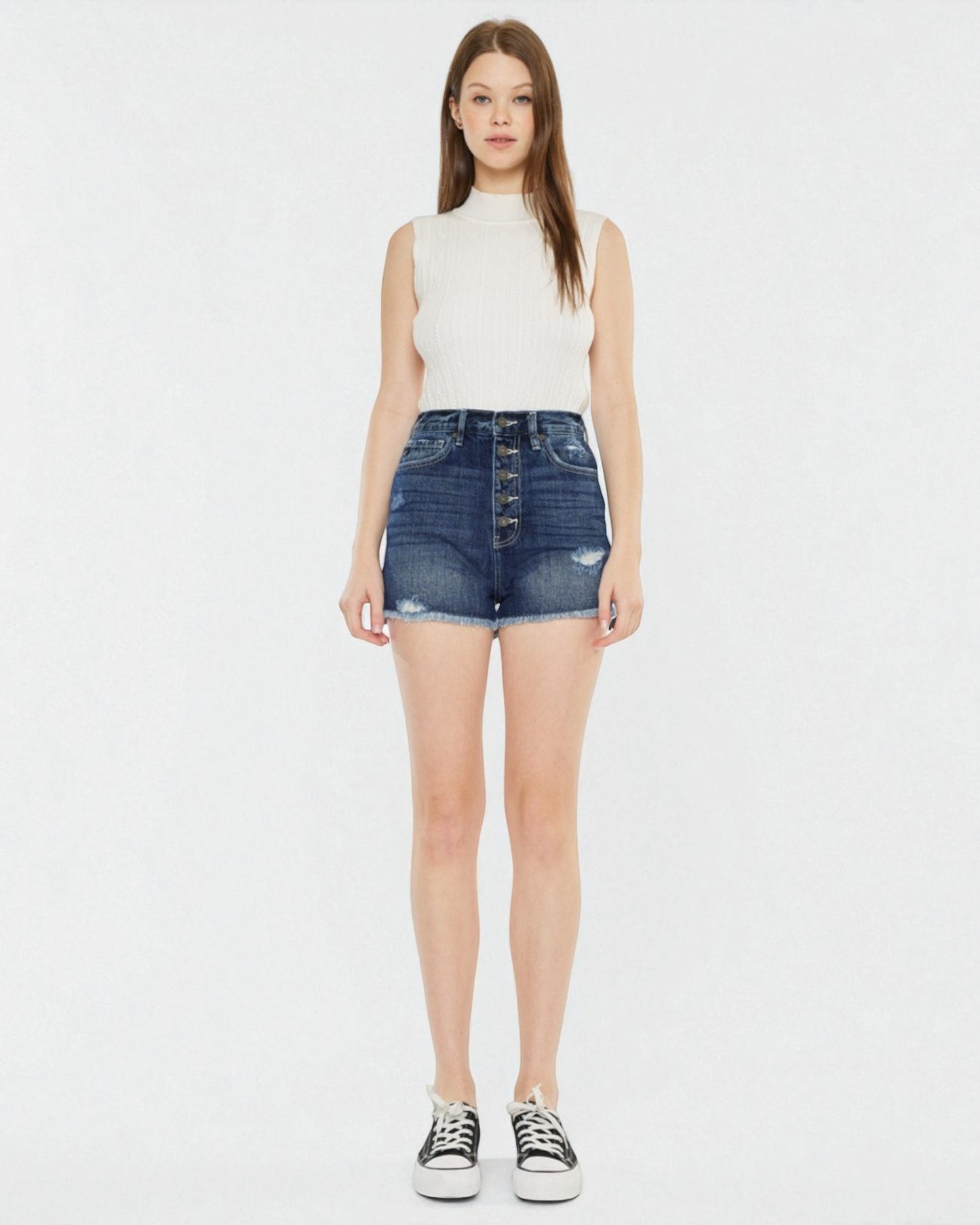 Woman wearing a white sleeveless top and denim skirt on a white background