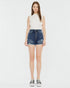 Woman wearing a white sleeveless top and denim skirt on a white background