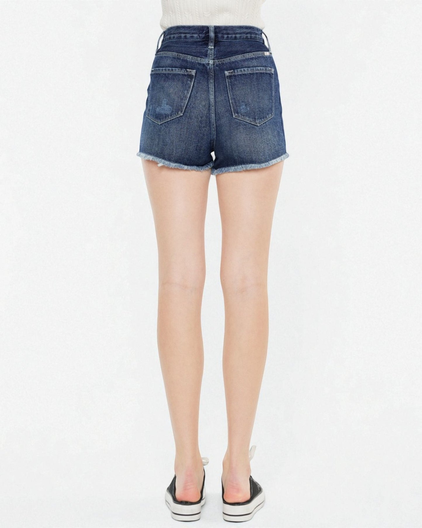 Blue denim shorts worn by a person on a white background