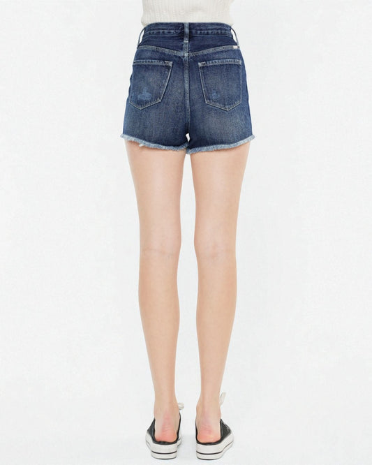 Blue denim shorts worn by a person on a white background