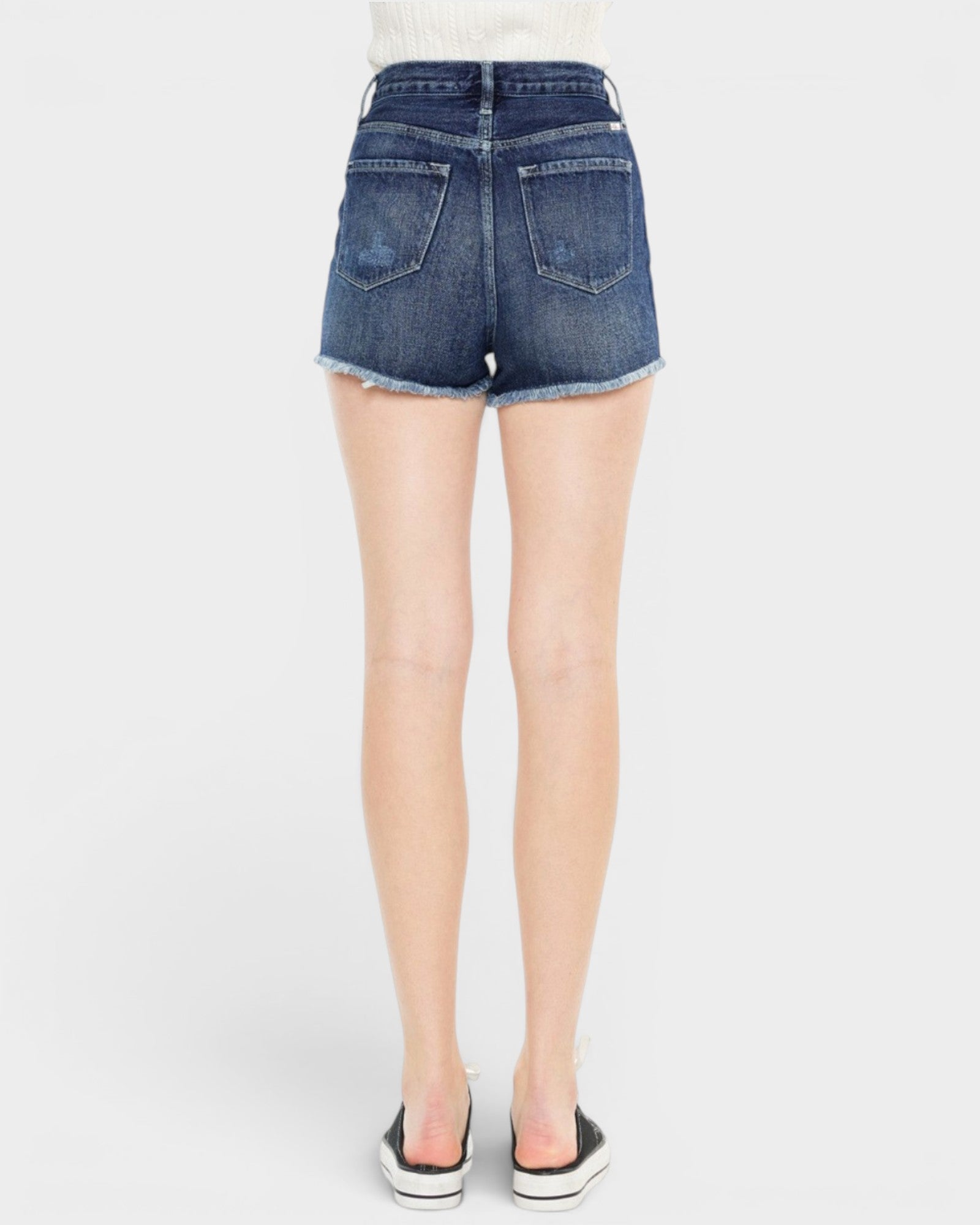 Blue denim shorts worn by a person on a white background