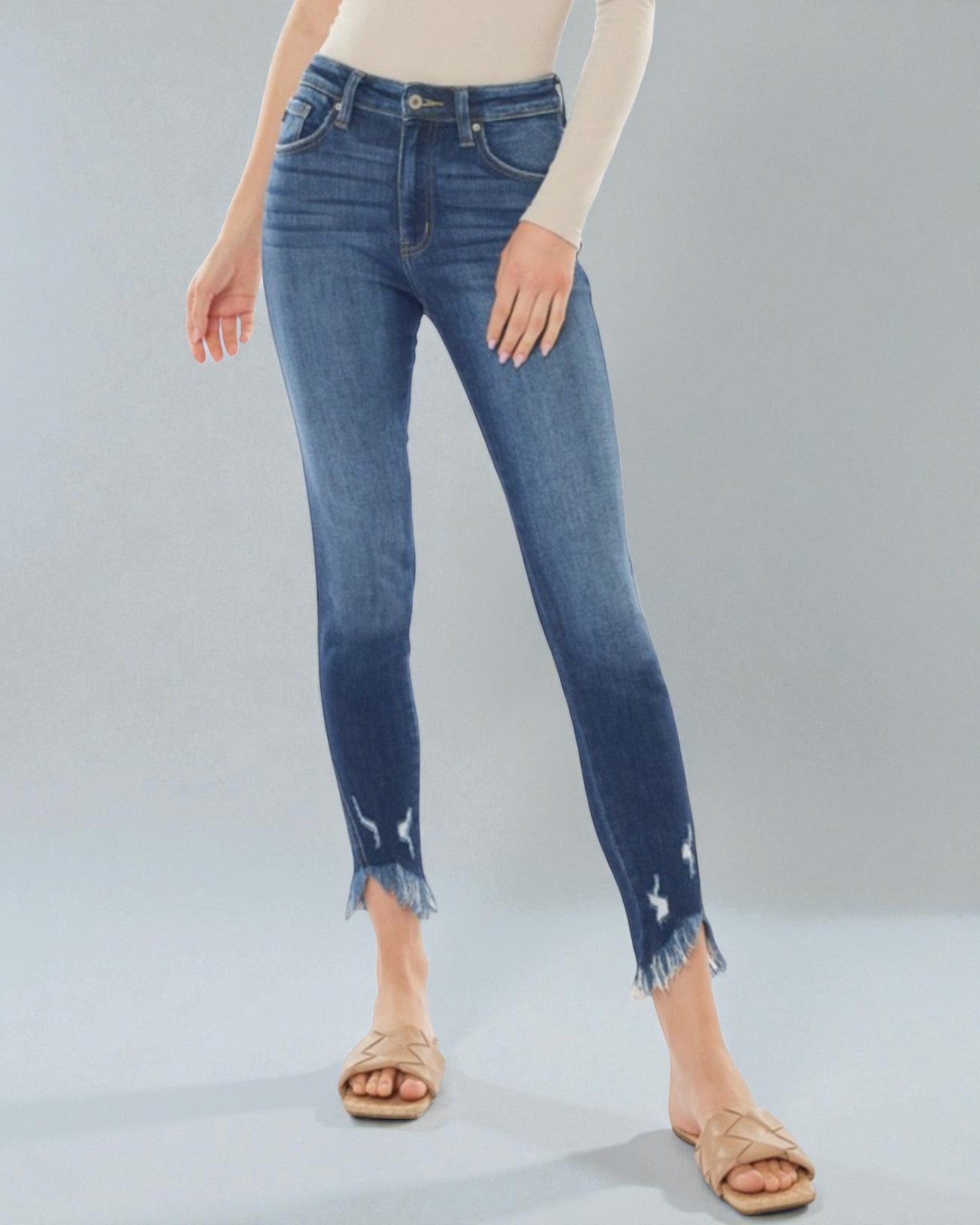 Person wearing blue jeans on a gray background
