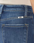 Close-up of blue jeans with a brand label on the back pocket.