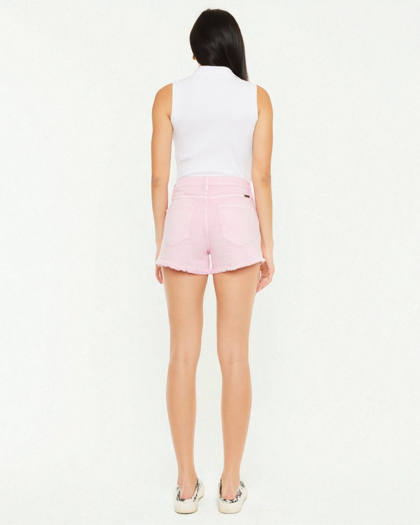 Person wearing a white sleeveless top and pink shorts on a white background