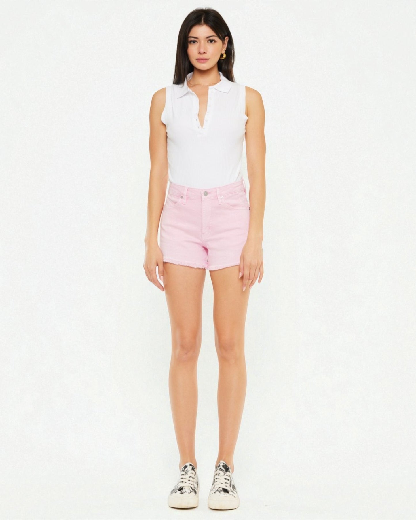 Woman wearing a white sleeveless top and pink shorts on a white background