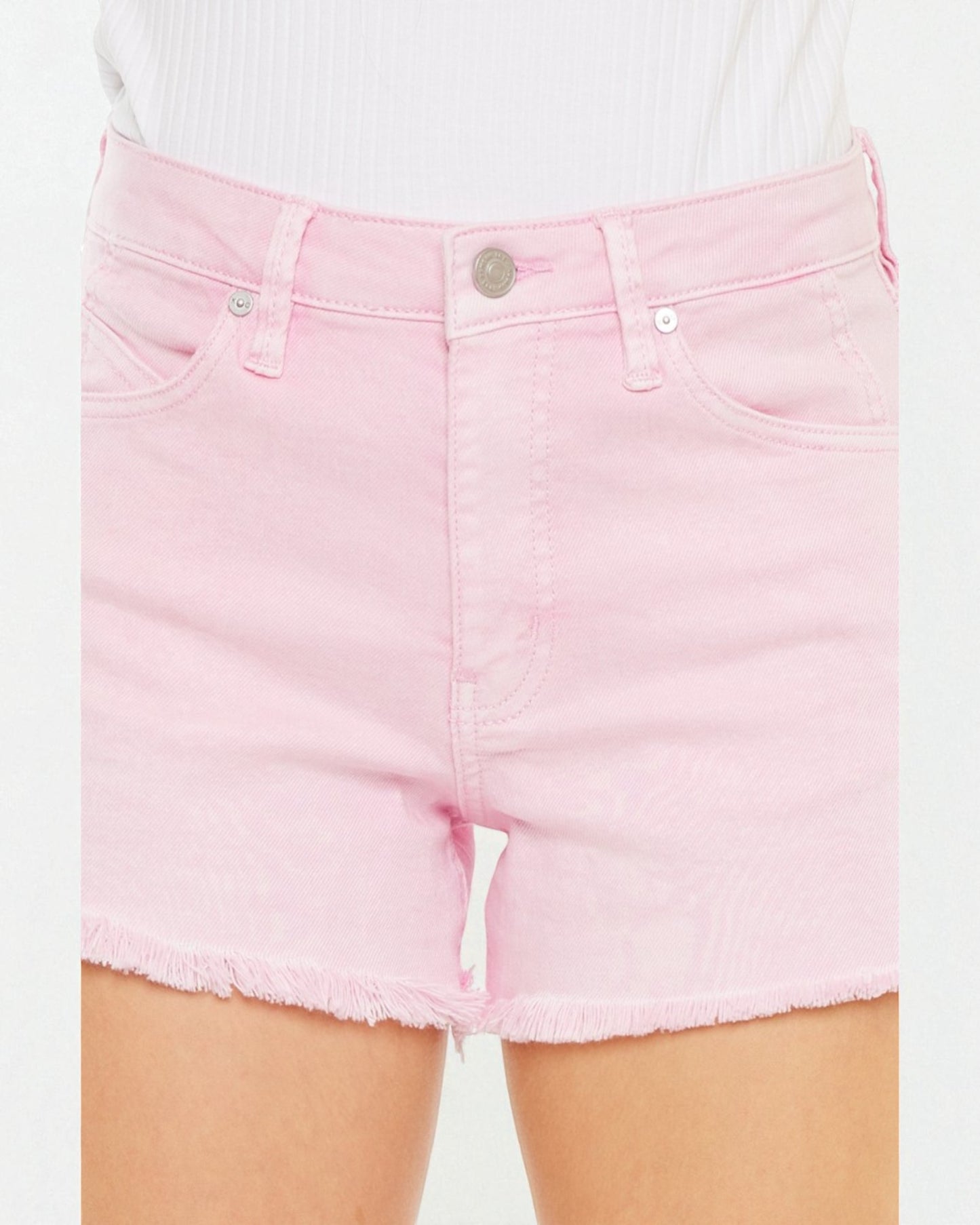Pink denim shorts worn by a person on a white background