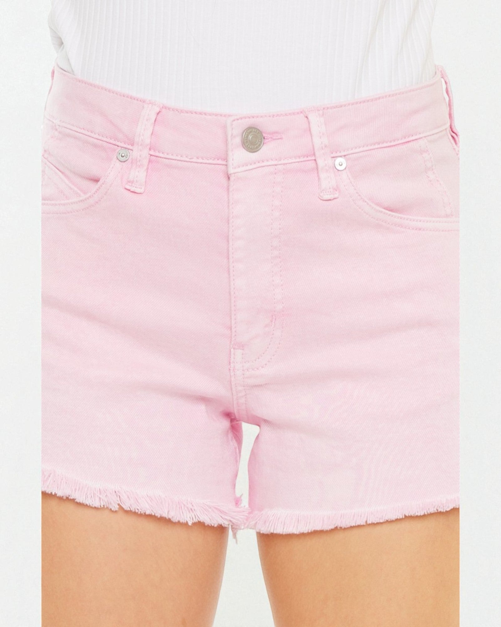 Pink denim shorts worn by a person on a white background