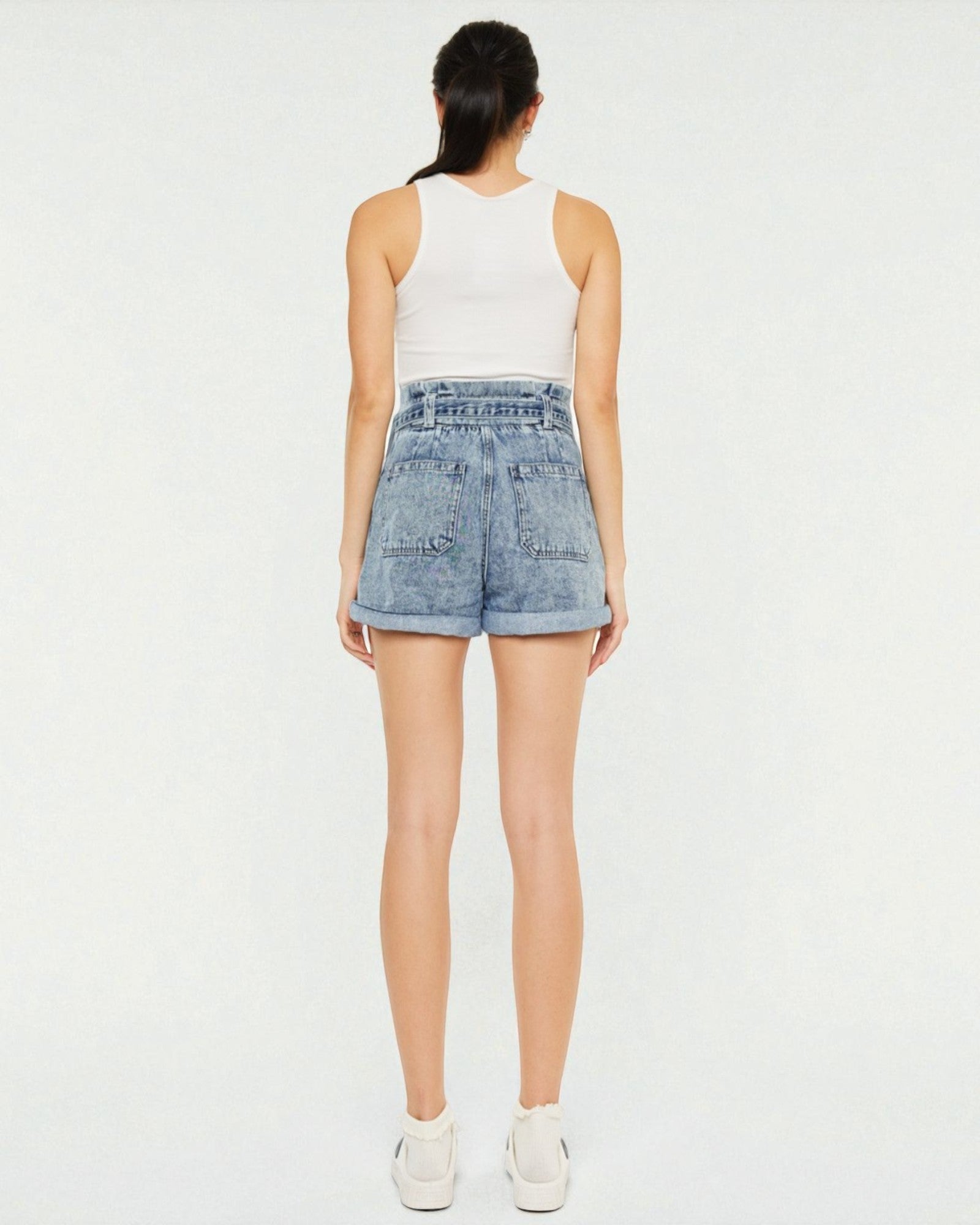 Person wearing light blue denim shorts on a white background