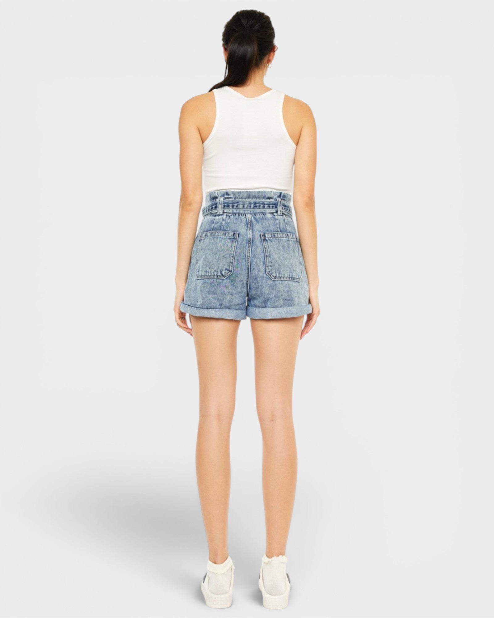 Person wearing light blue denim shorts on a white background