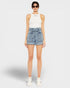 Woman wearing a white sleeveless top and denim shorts on a white background