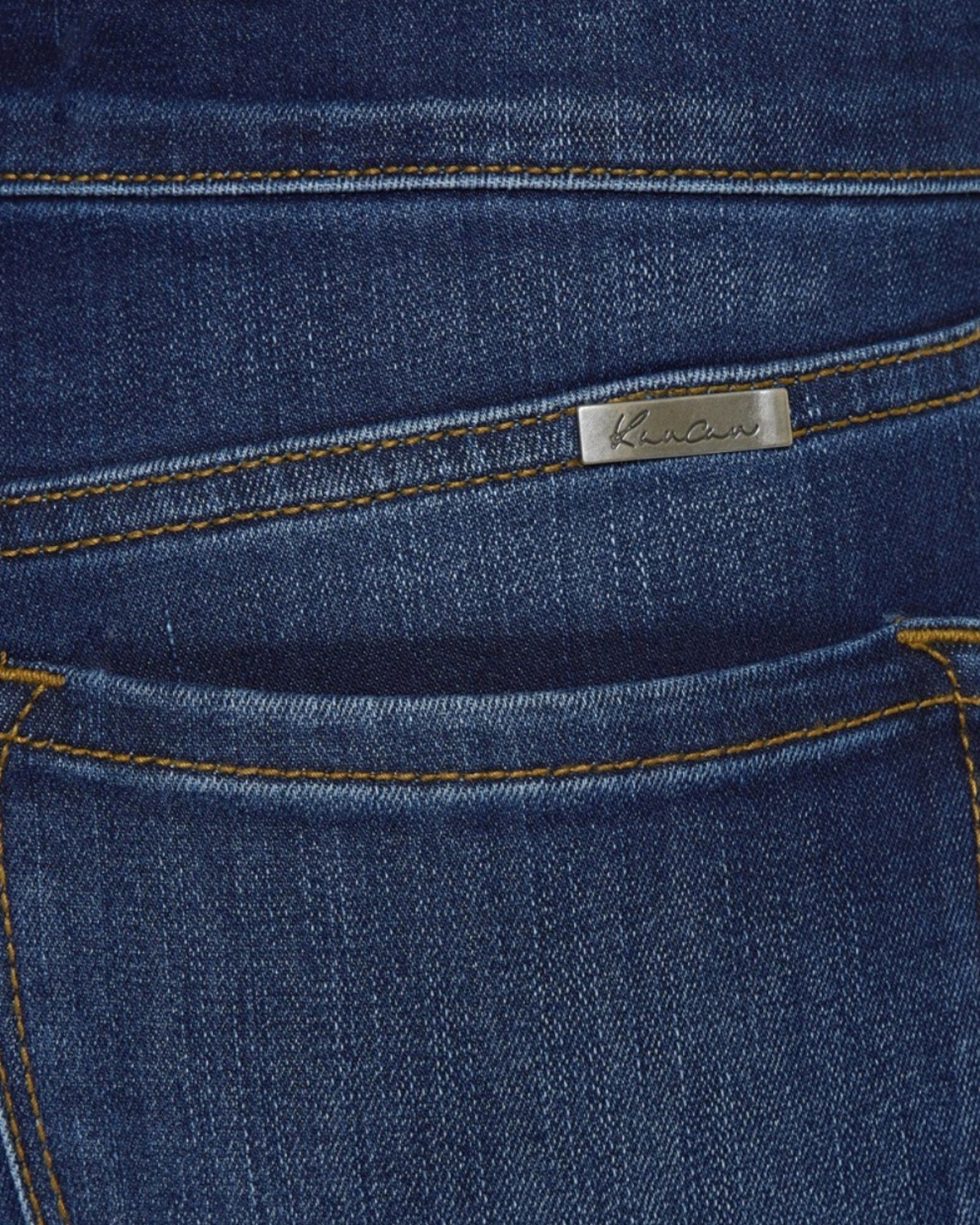 Close-up of blue denim fabric with a brand label.