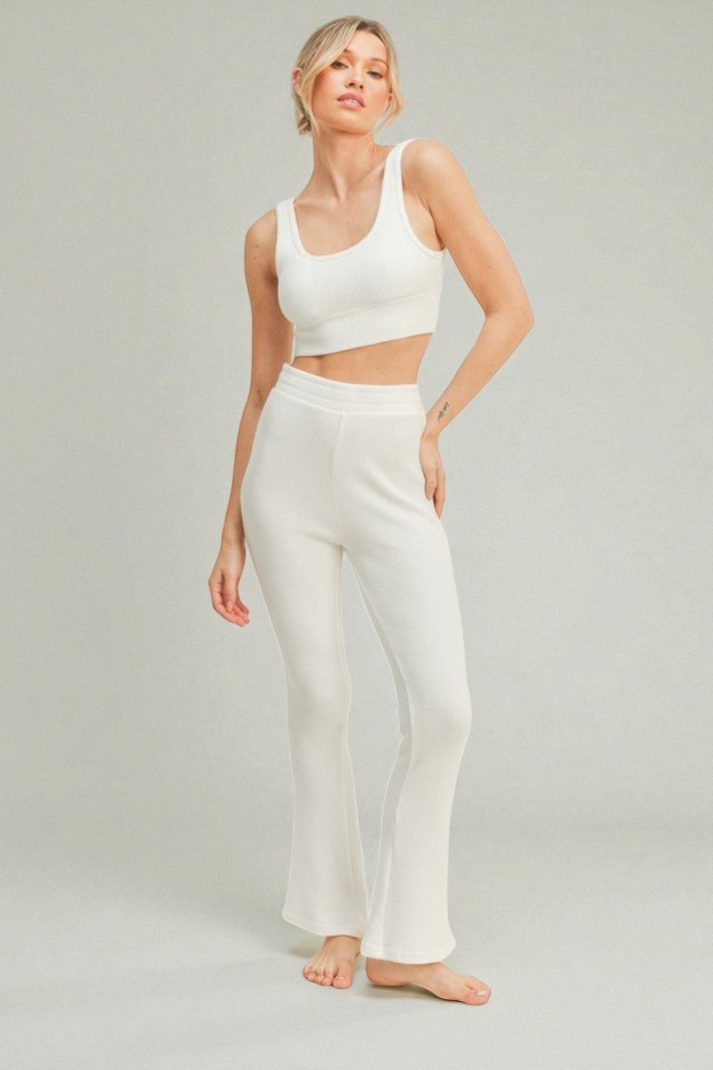 Woman wearing a white outfit on a plain background