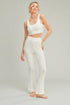 Woman wearing a white outfit on a plain background
