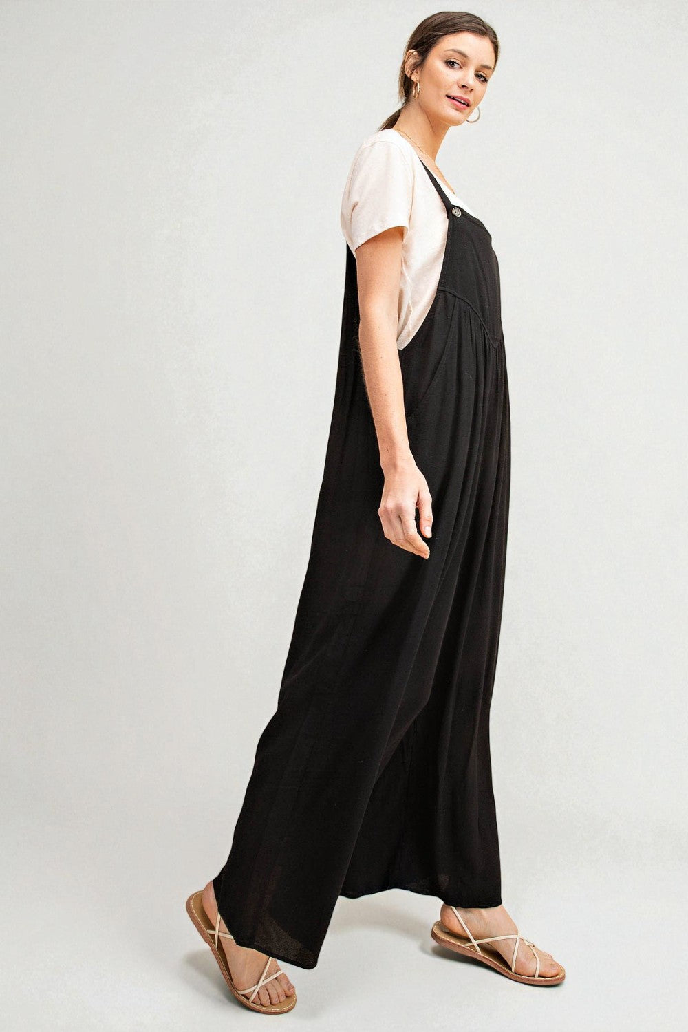 Woman wearing a black dress with a white top on a plain background