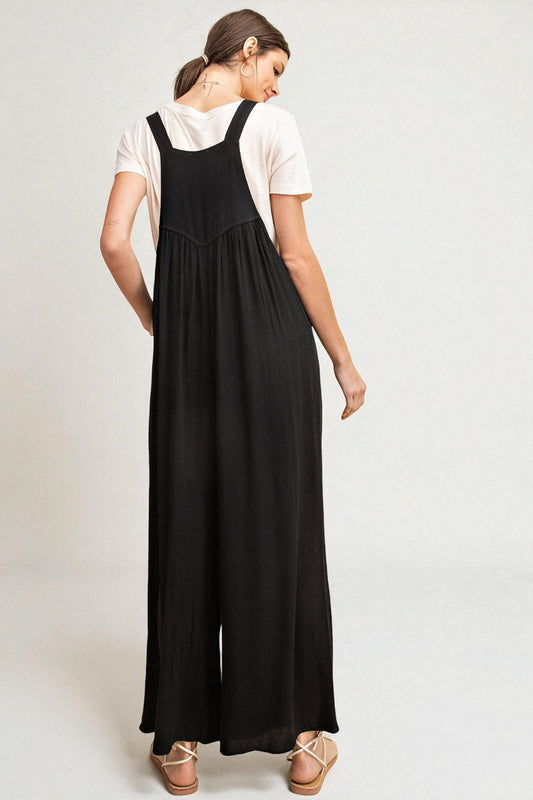 Woman wearing a black dress over a white shirt on a plain background