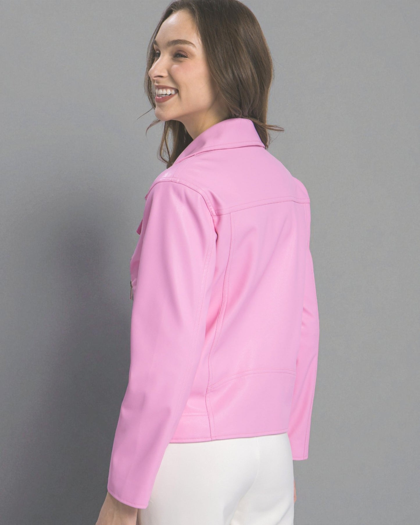 Woman wearing a pink jacket against a gray background