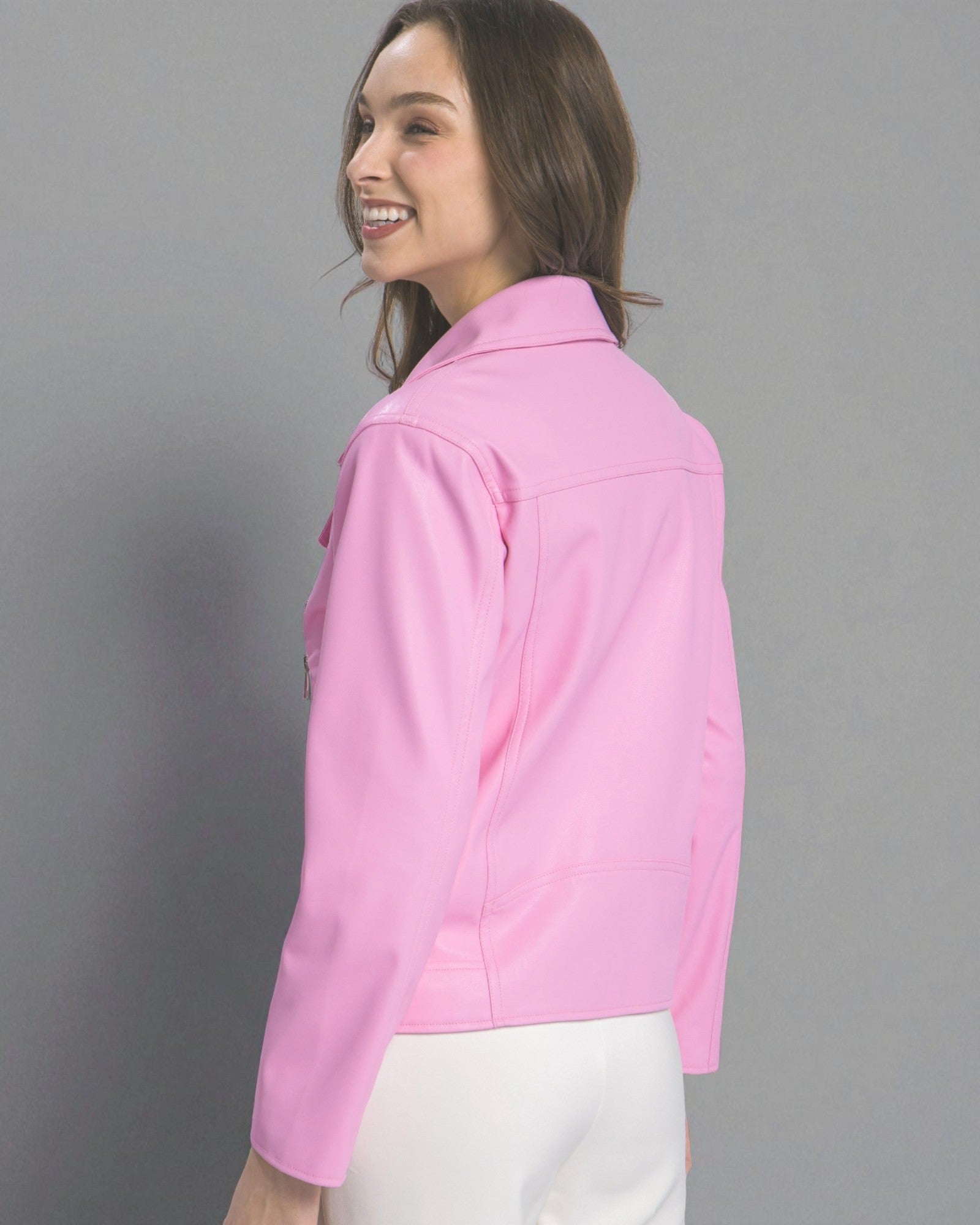 Woman wearing a pink jacket against a gray background
