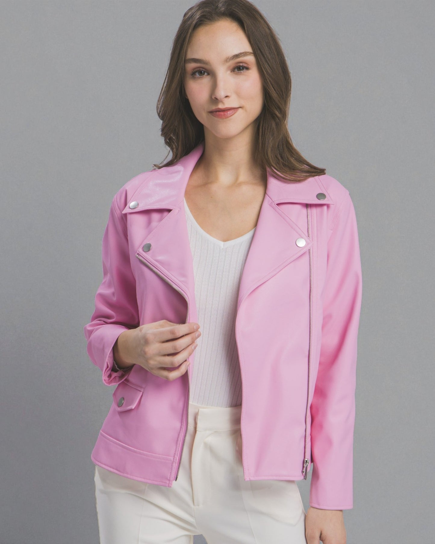 Woman wearing a pink jacket against a gray background