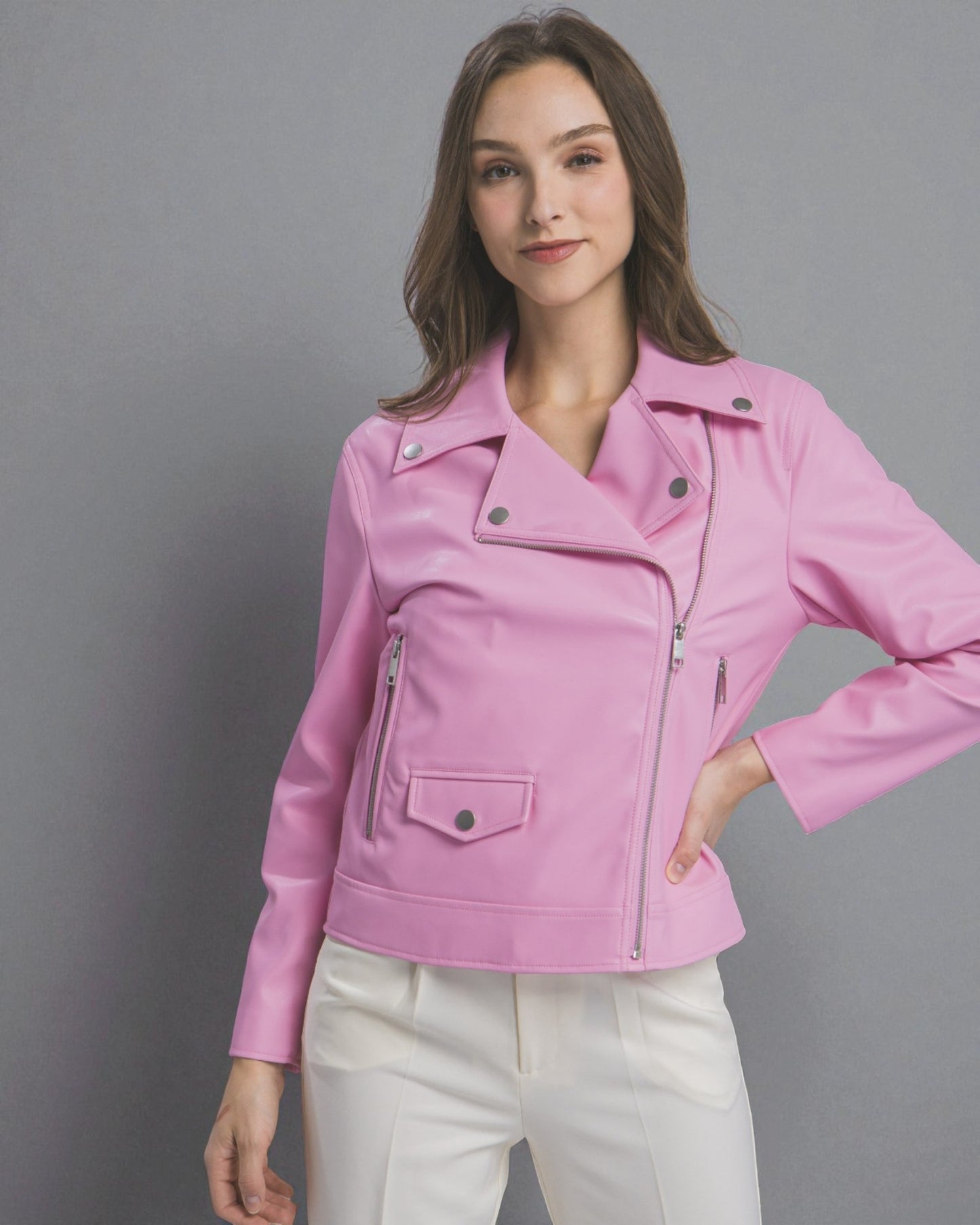 Woman wearing a pink jacket against a gray background