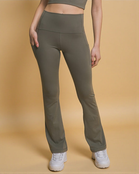 Person wearing olive green pants on a beige background