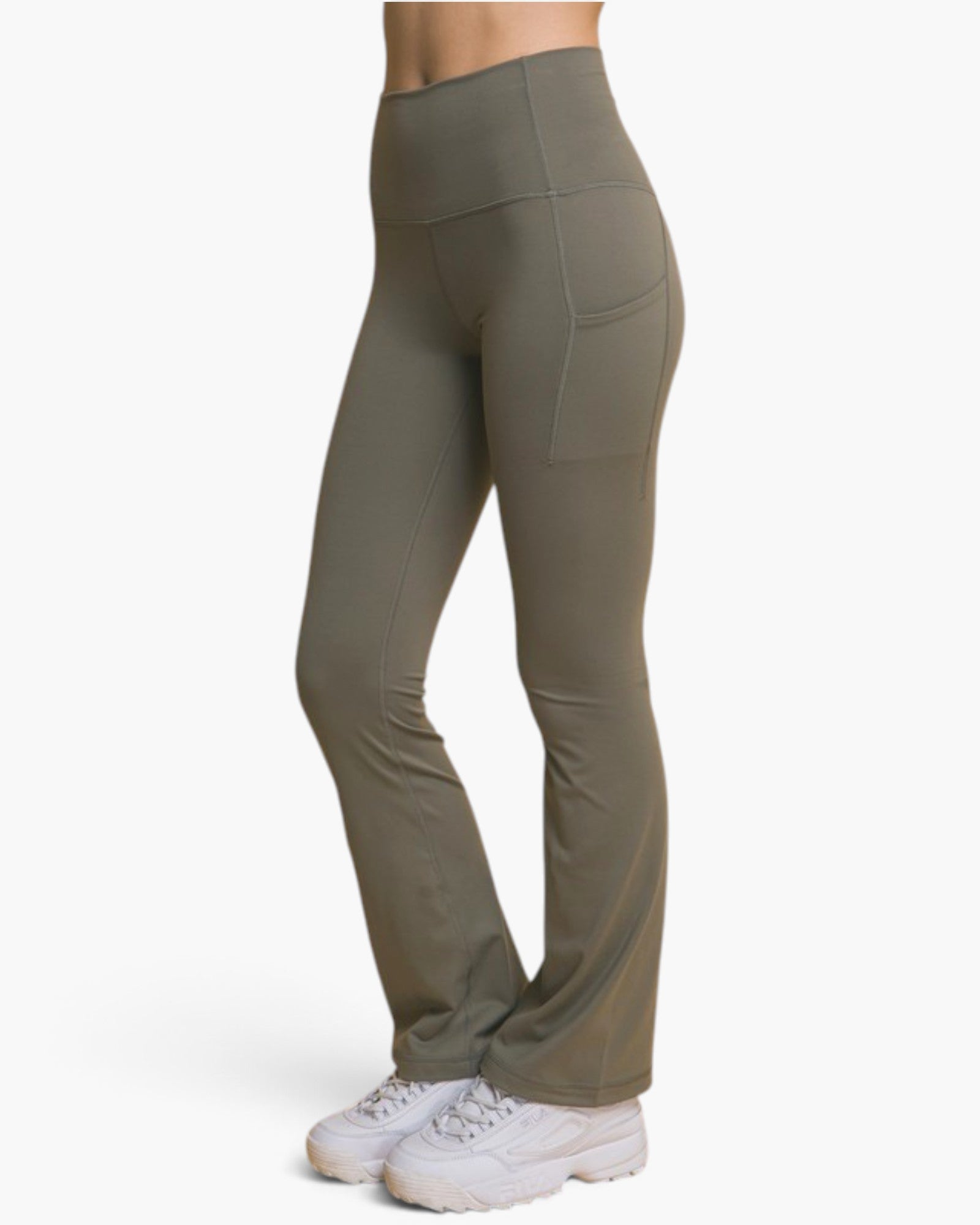 A person wearing high-waisted olive green athletic pants with side pockets and white sneakers, shown from the waist down against a plain light background.