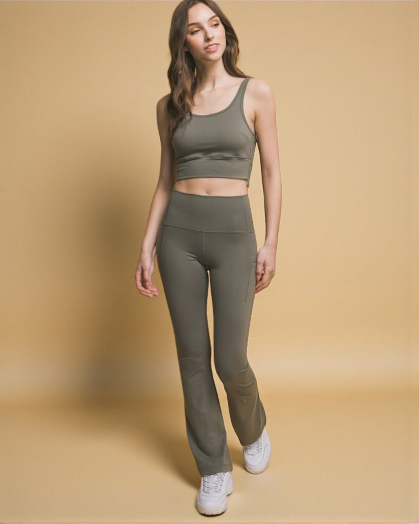 Woman wearing a green athletic outfit on a beige background