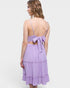 Woman wearing a purple dress with a bow detail on a white background