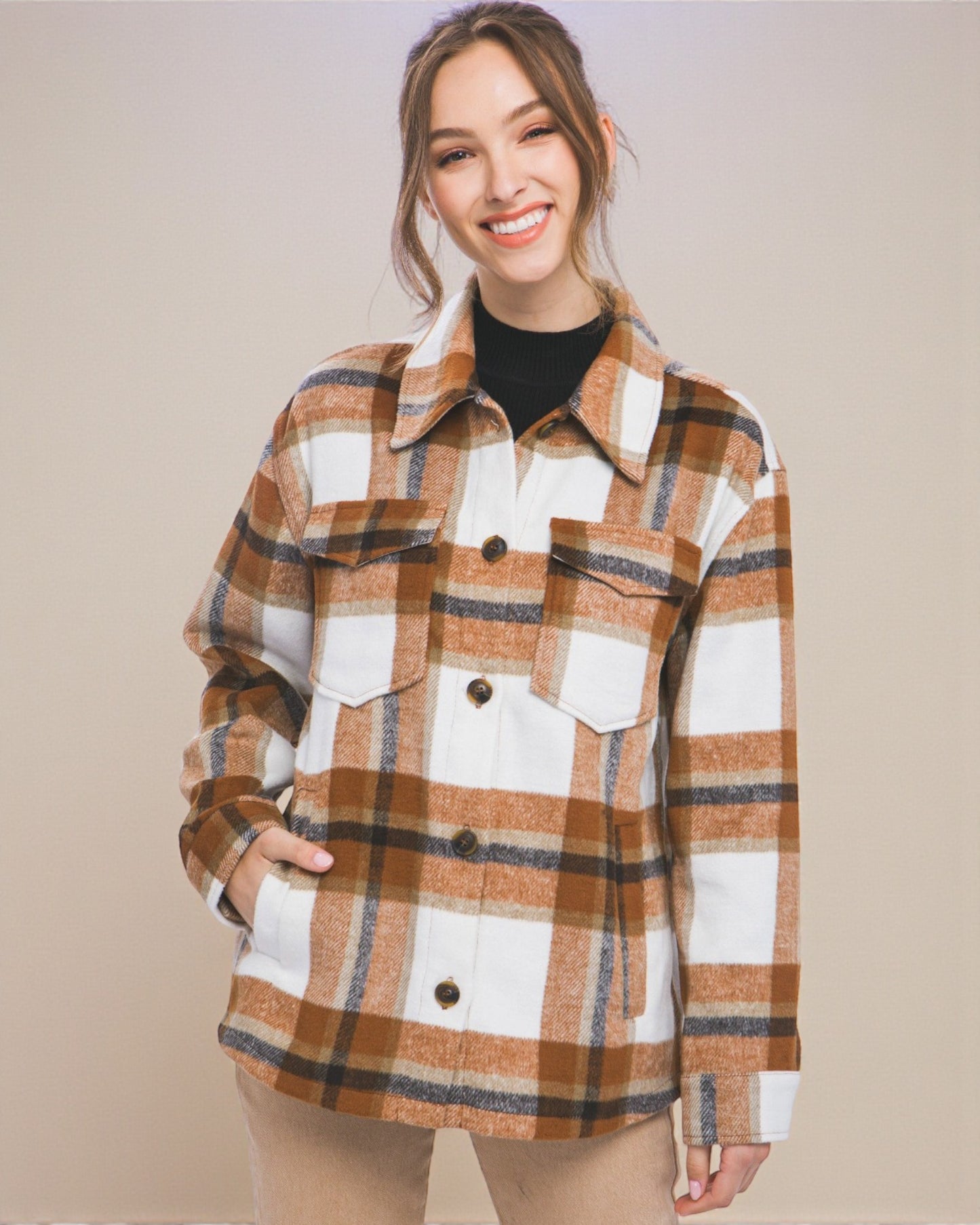 Woman wearing a plaid shirt over a black top against a beige background