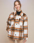 Woman wearing a plaid shirt over a black top against a beige background