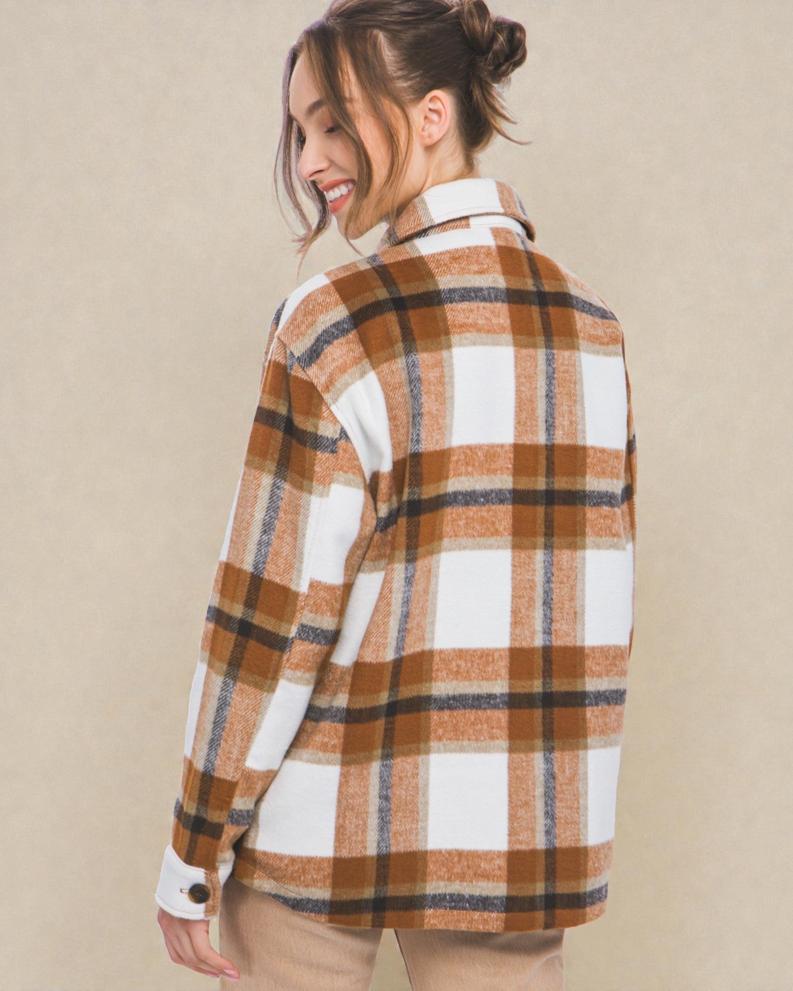 Woman wearing a plaid shirt with a beige background