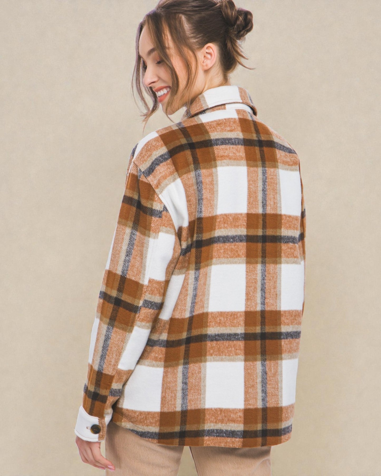 Woman wearing a plaid shirt with a beige background