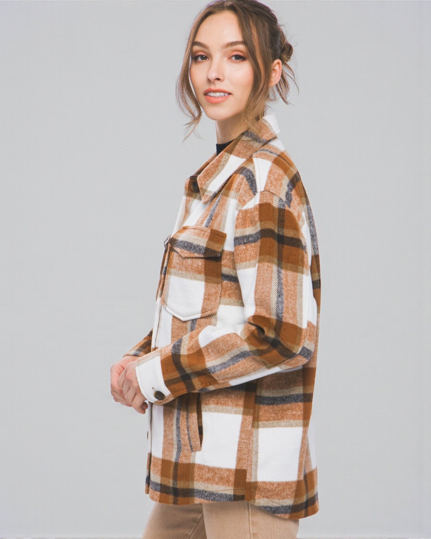 Woman wearing a plaid shirt with a neutral background