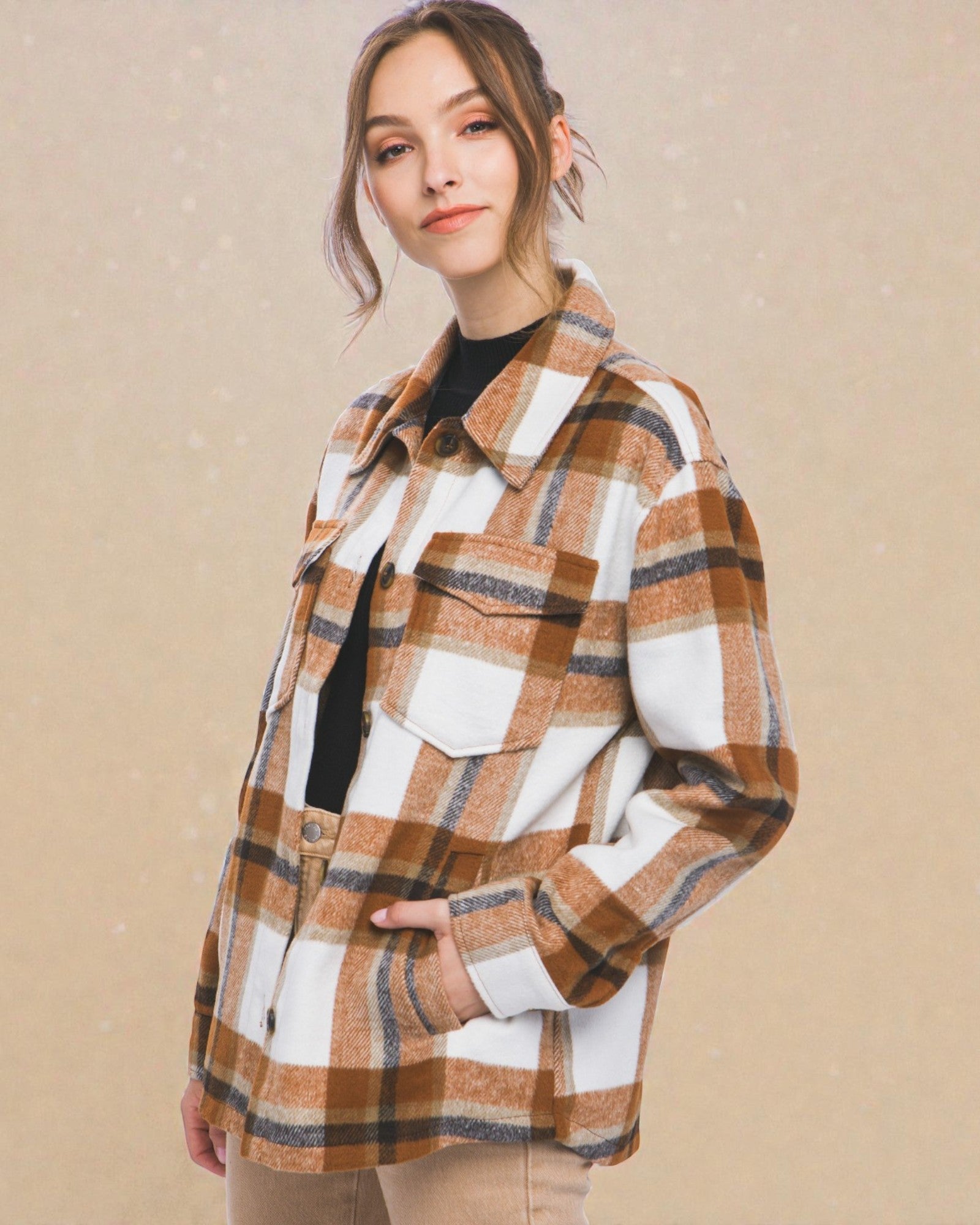 Person wearing a plaid shirt against a beige background