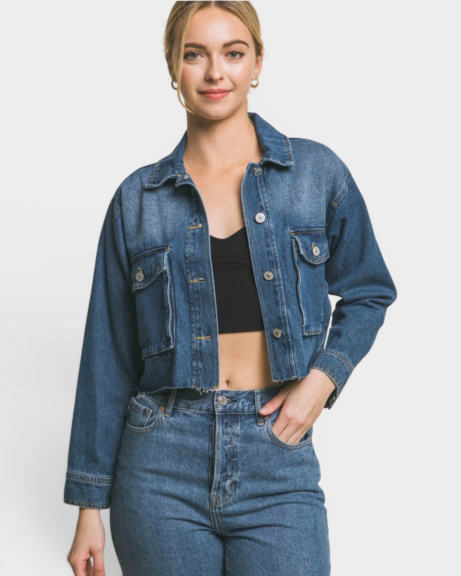 Person wearing a blue denim jacket and jeans on a white background