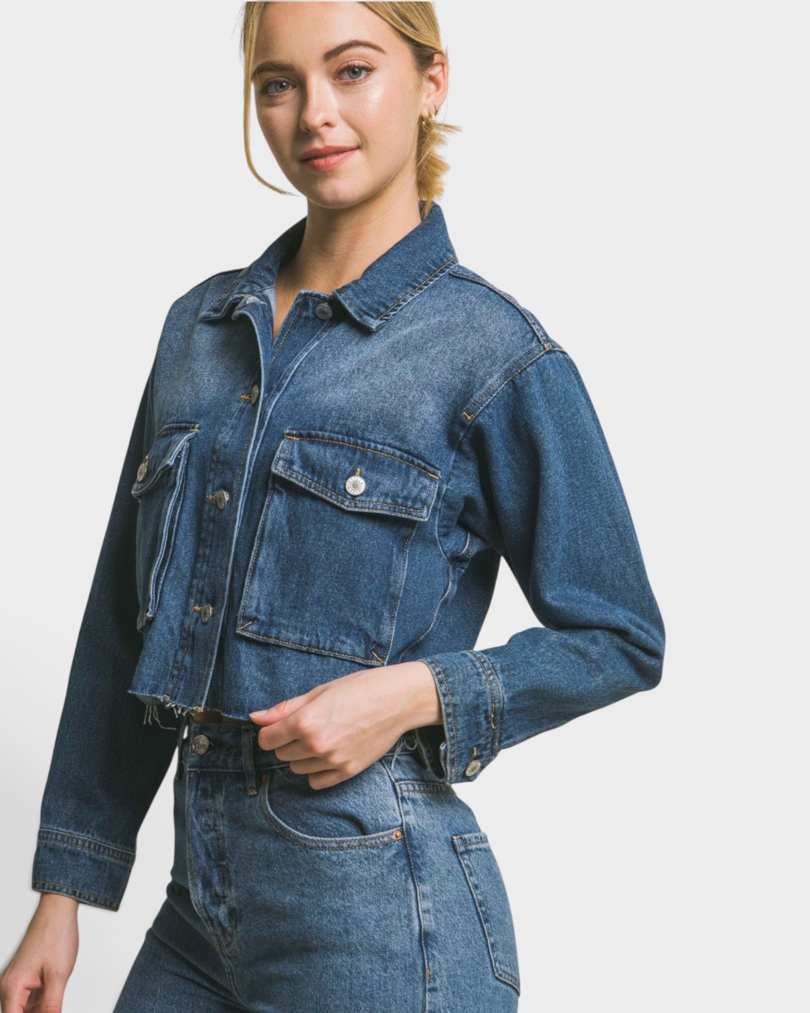 Woman wearing a blue denim jacket and pants on a white background