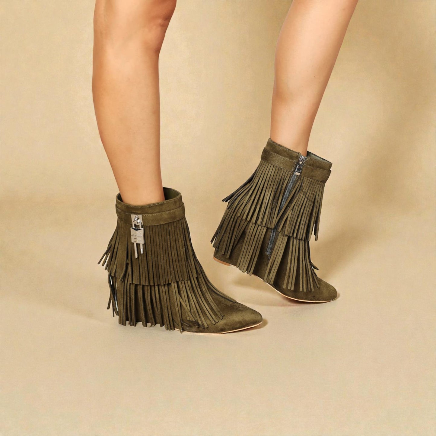 Green fringe boots worn by a person on a beige background
